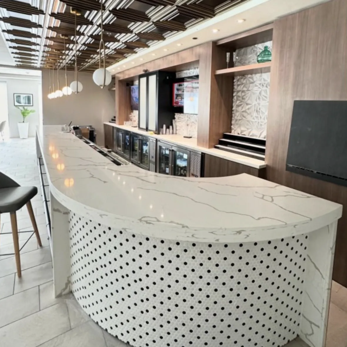 Curved quartz bar counter with penny tile base