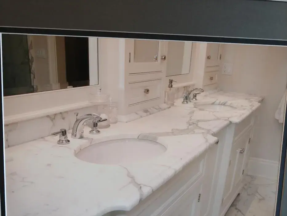 Marble vanity top with two undermount sinks and a matching marble backsplash