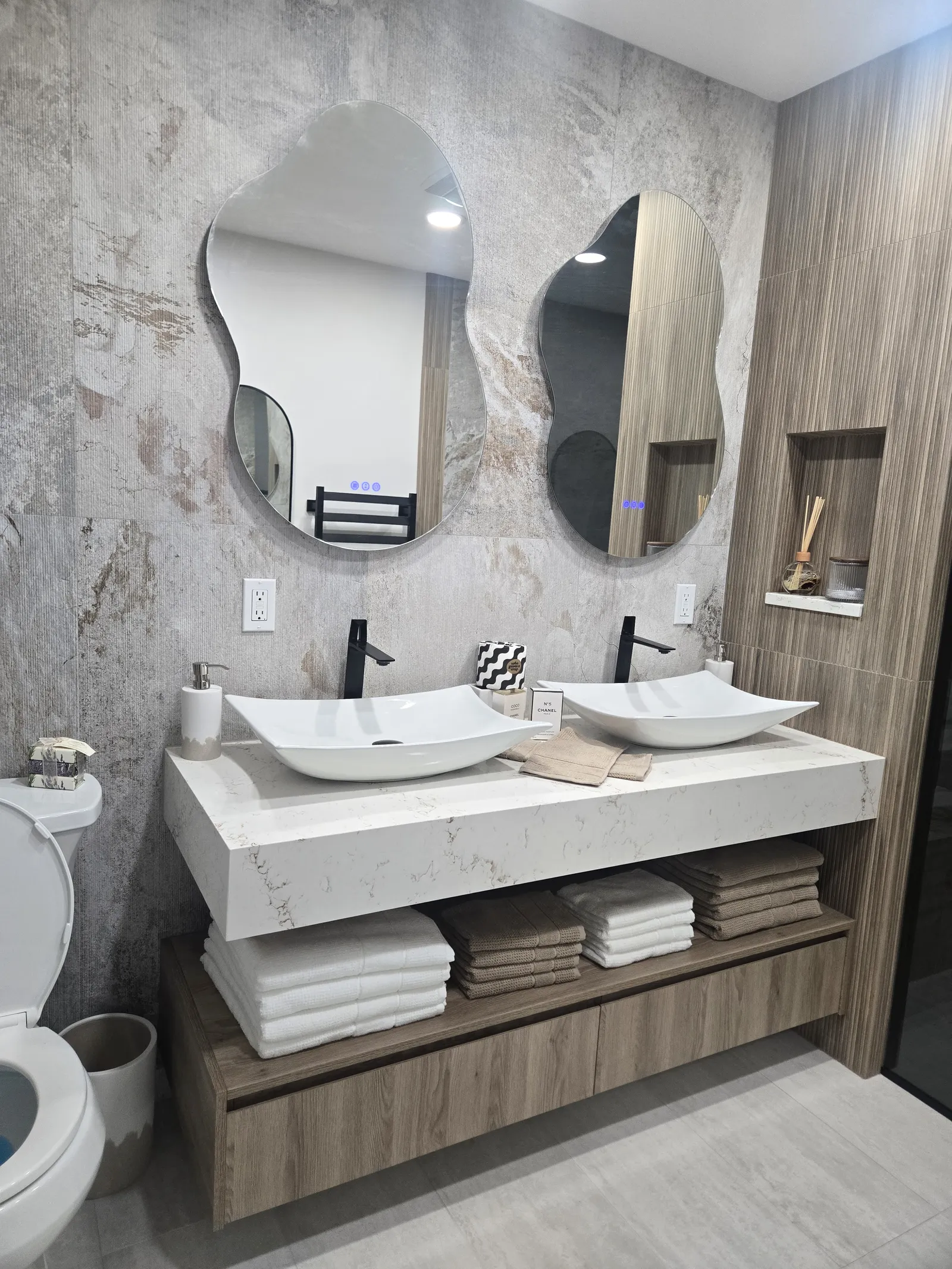 Floating double vanity with a stone countertop and stone wall panels