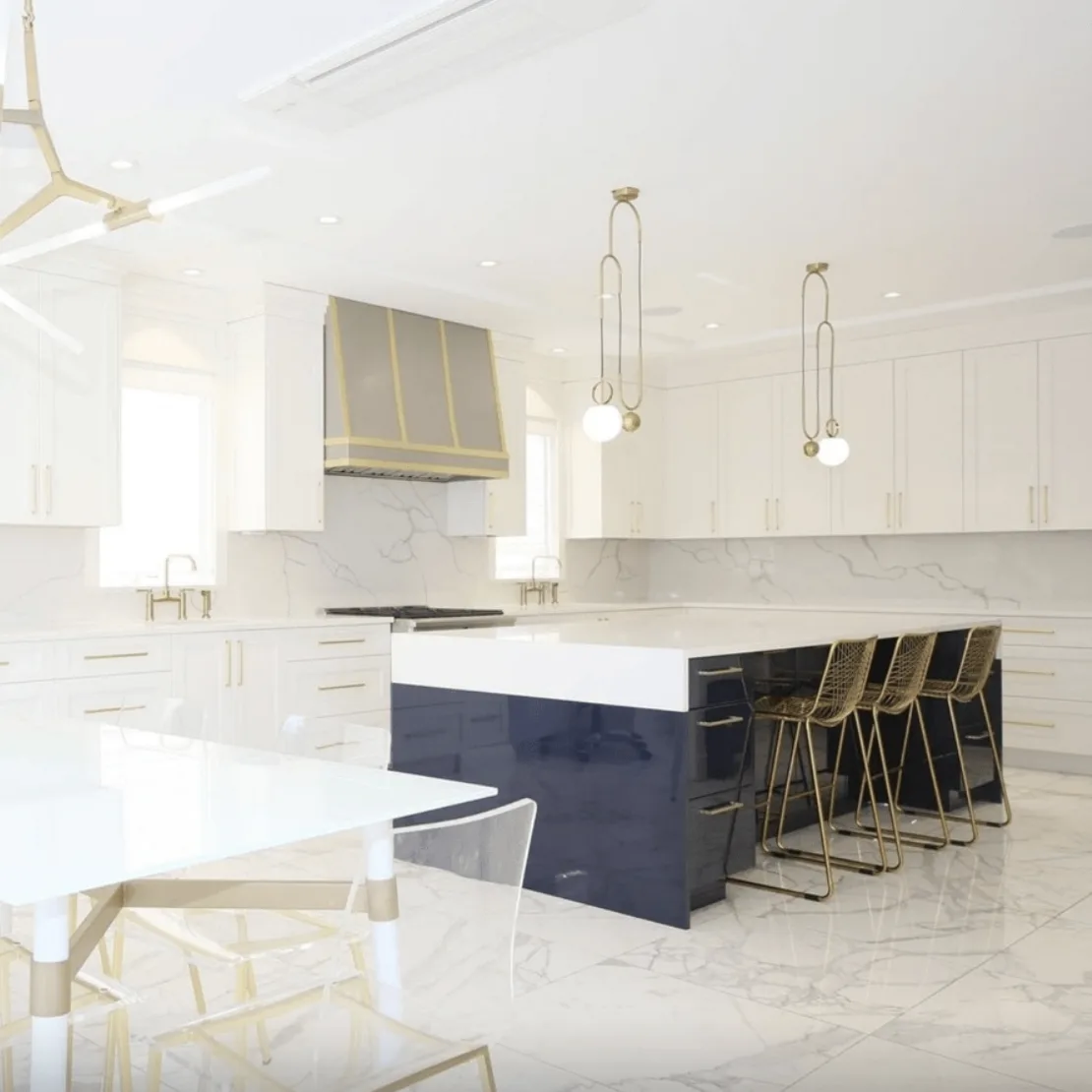 Calacatta Vagli quartz kitchen with white perimeter counters and a navy waterfall island