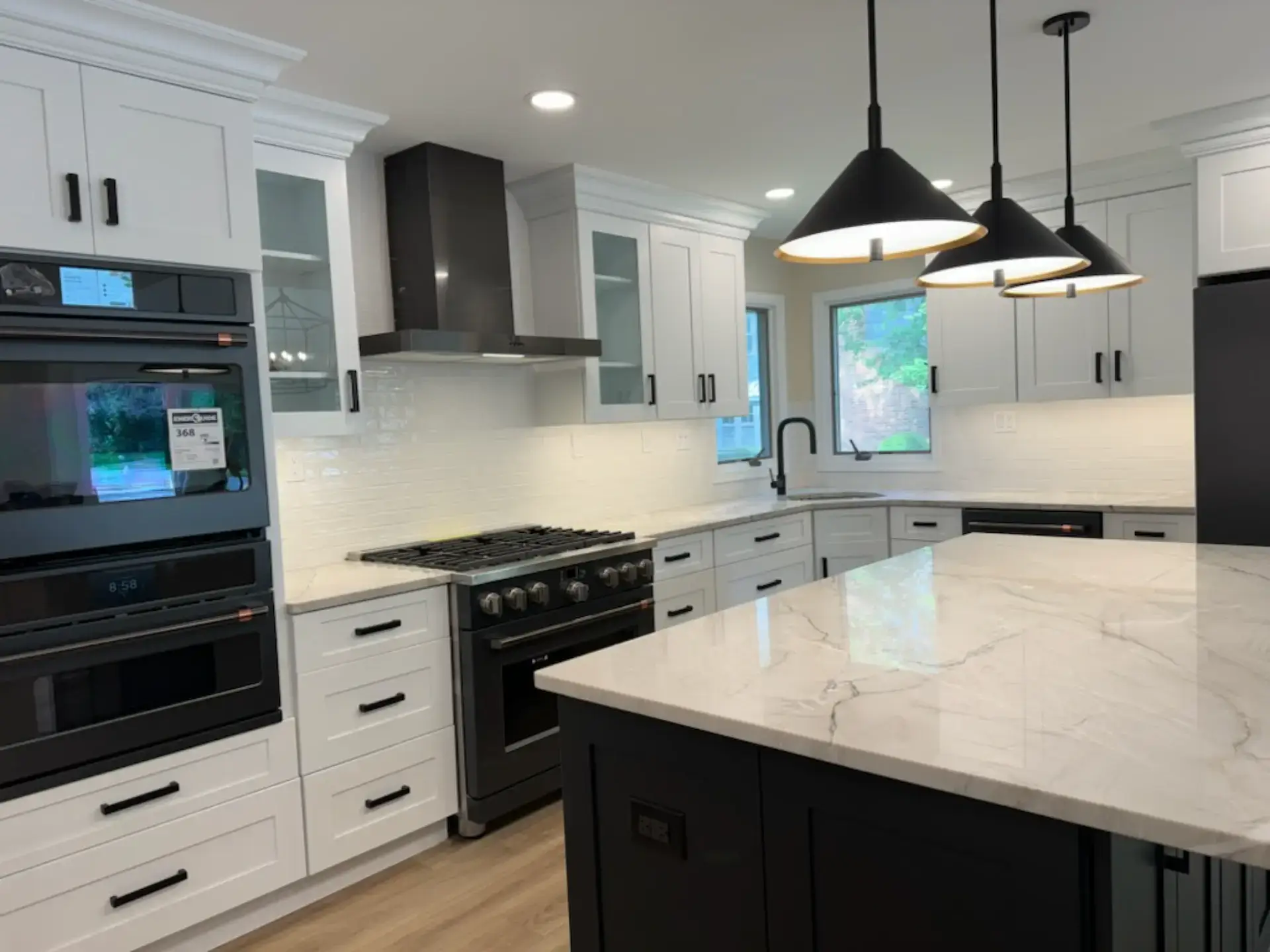 White veined stone counters with a black hood and double oven