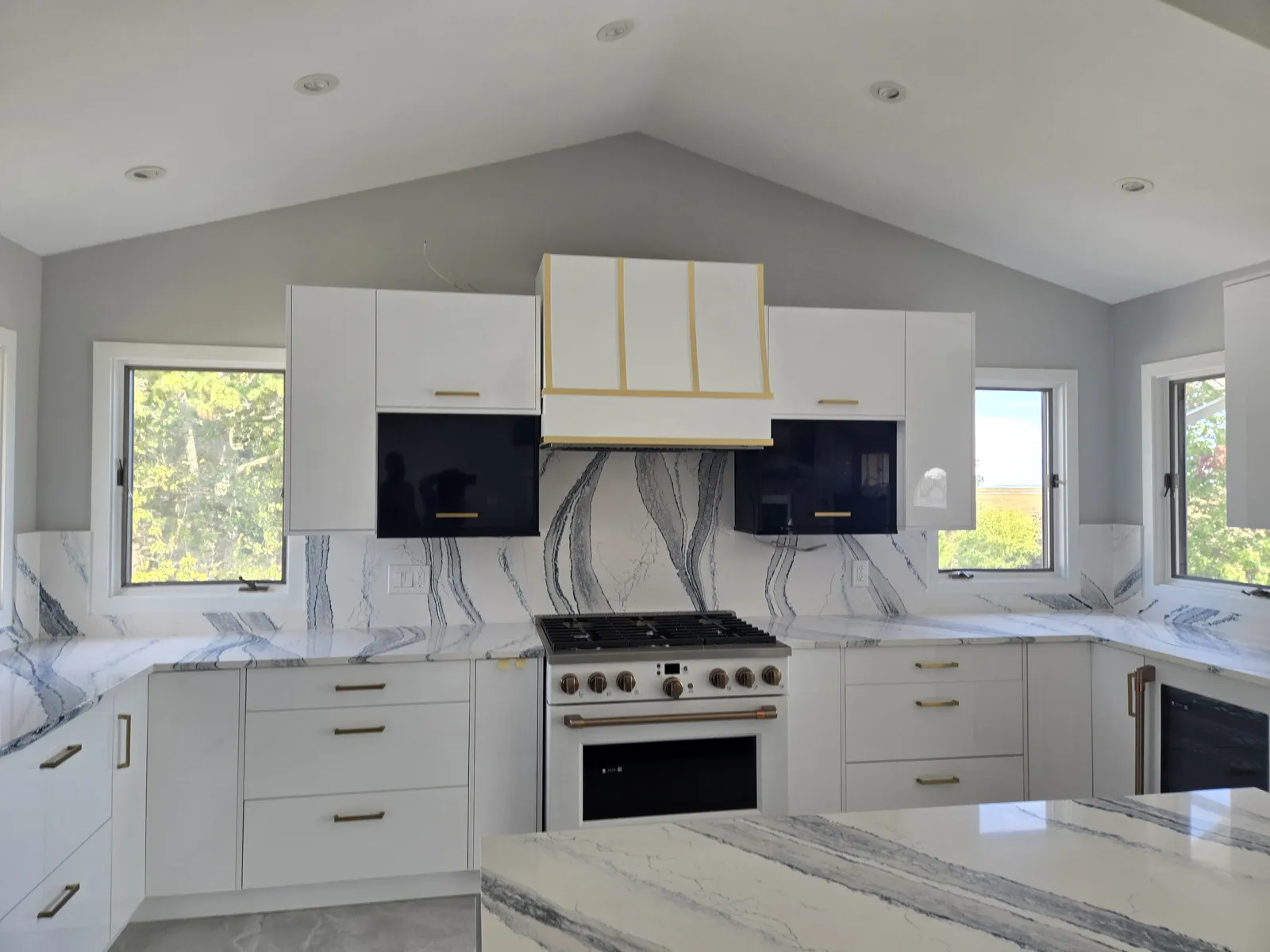 Full height veined stone backsplash behind a range with a matching countertop
