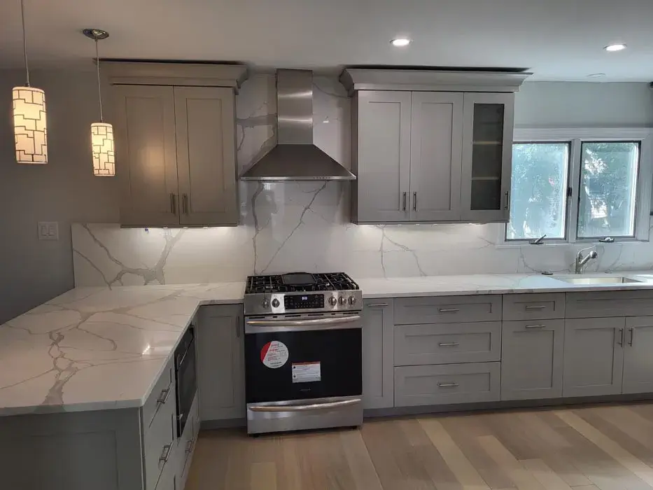 Marble look countertops and full height backsplash behind a range