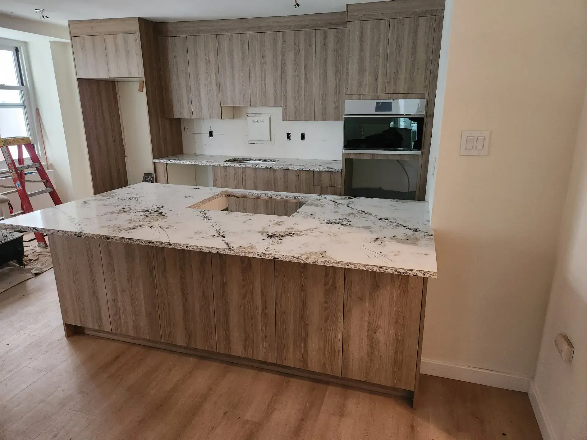 Veined stone island top set on its cabinetry during a kitchen install