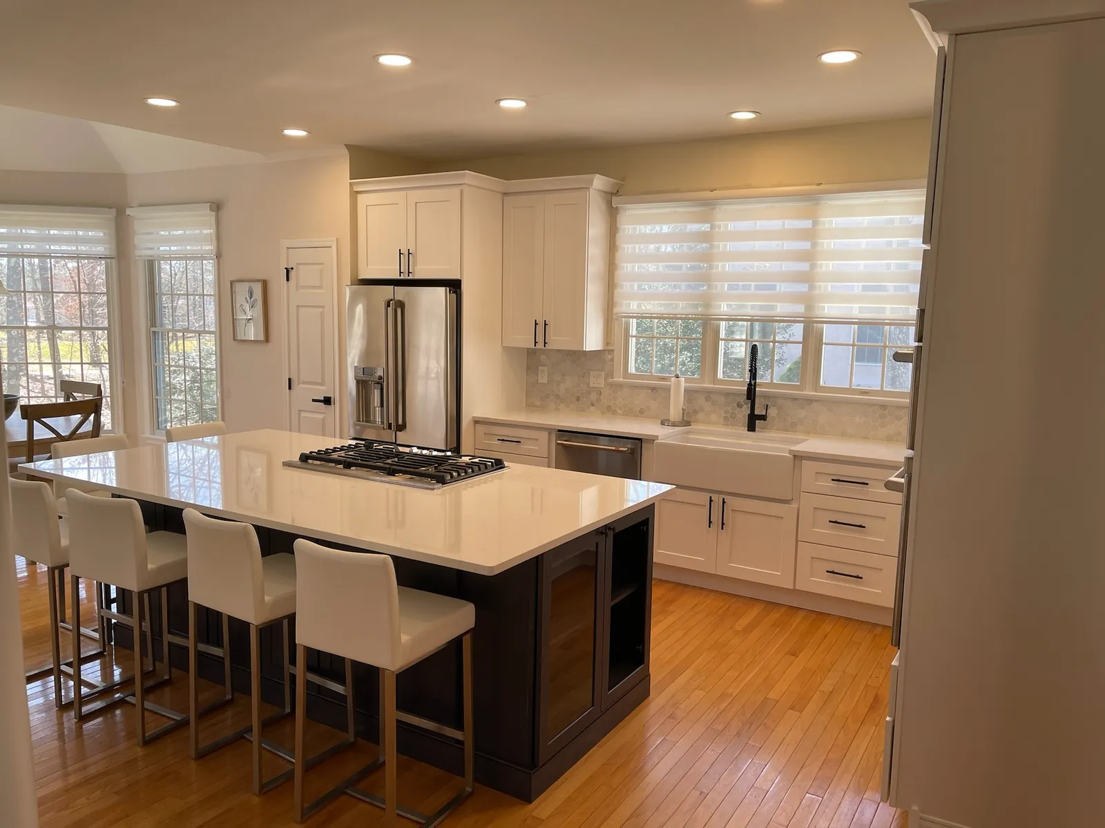 Glossy white kitchen with a walnut island and a white stone top