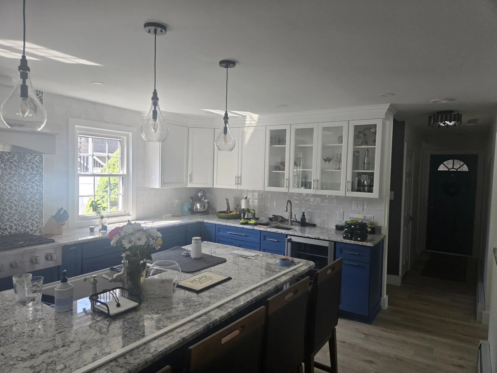 Granite countertops on navy cabinets along a range wall
