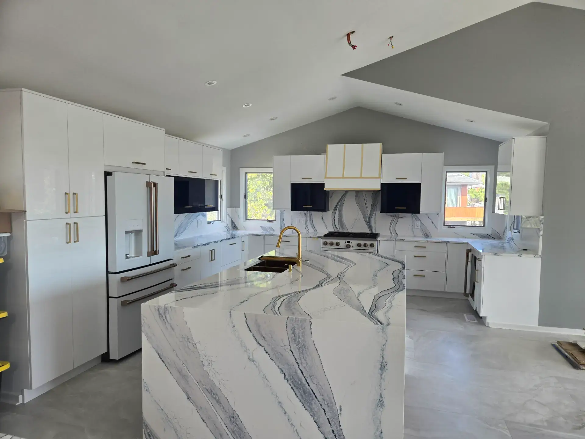 Waterfall island and range wall backsplash cut from the same veined slab