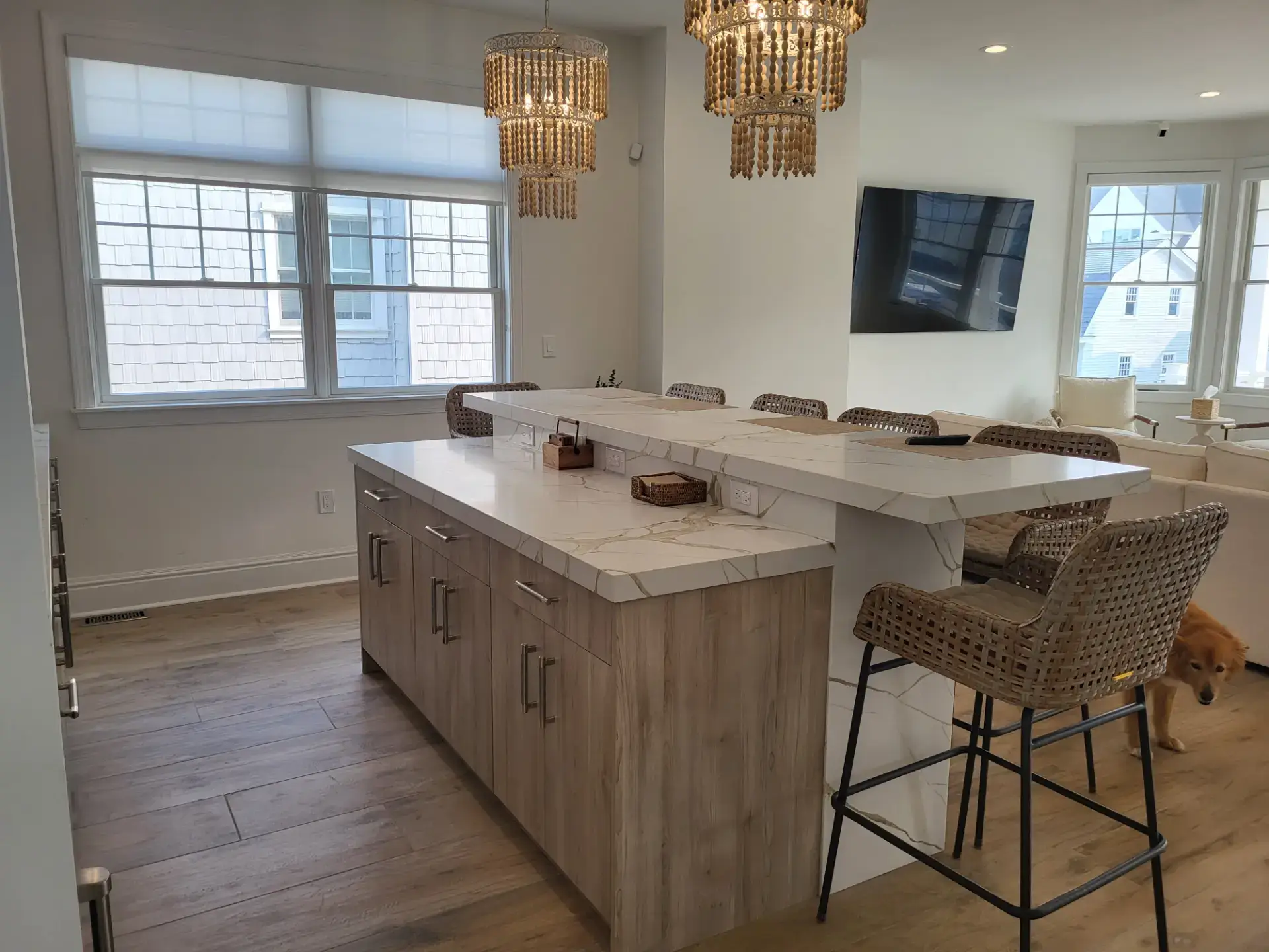 Stained wood island with a veined stone top and woven stools