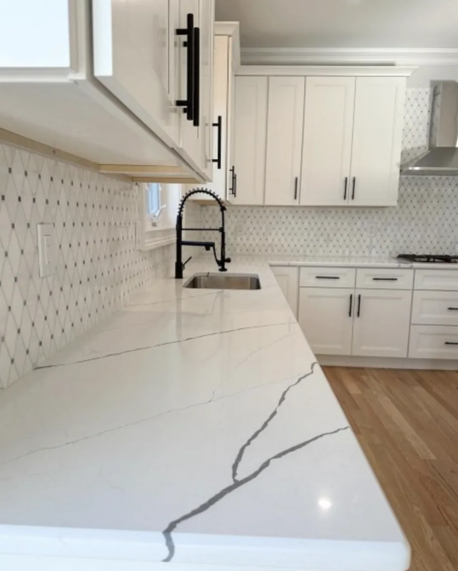 Quartz countertop with marble mosaic backsplash and matte black faucet